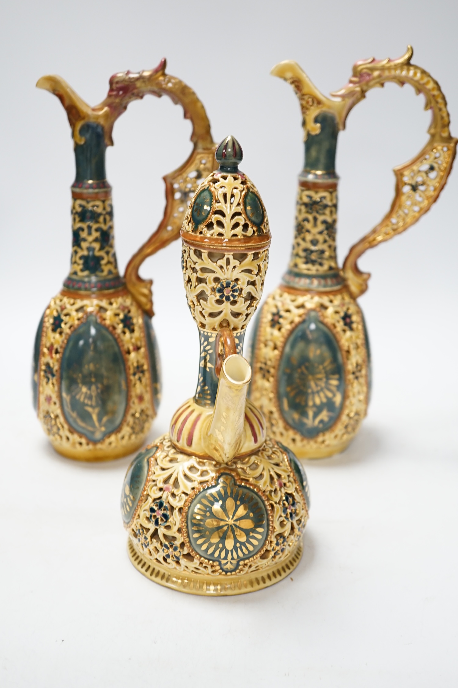 A pair of Zsolnay ewers and a similar ewer with cover, tallest 30cm high